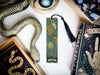 a bookmark with a snake on it next to other books