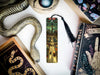 a bookmark with a snake and a book on it
