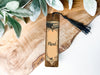 a wooden bookmark with a tassel on top of it