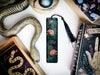 a bookmark with a snake and flowers on it