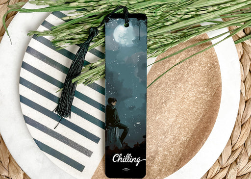 a bookmark sitting on top of a plate next to a plant