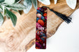 a bookmark sitting on top of a wooden table next to a plant