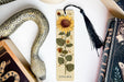 a bookmark with a sunflower on it next to other books