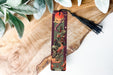 a bookmark sitting on top of a wooden table next to a plant