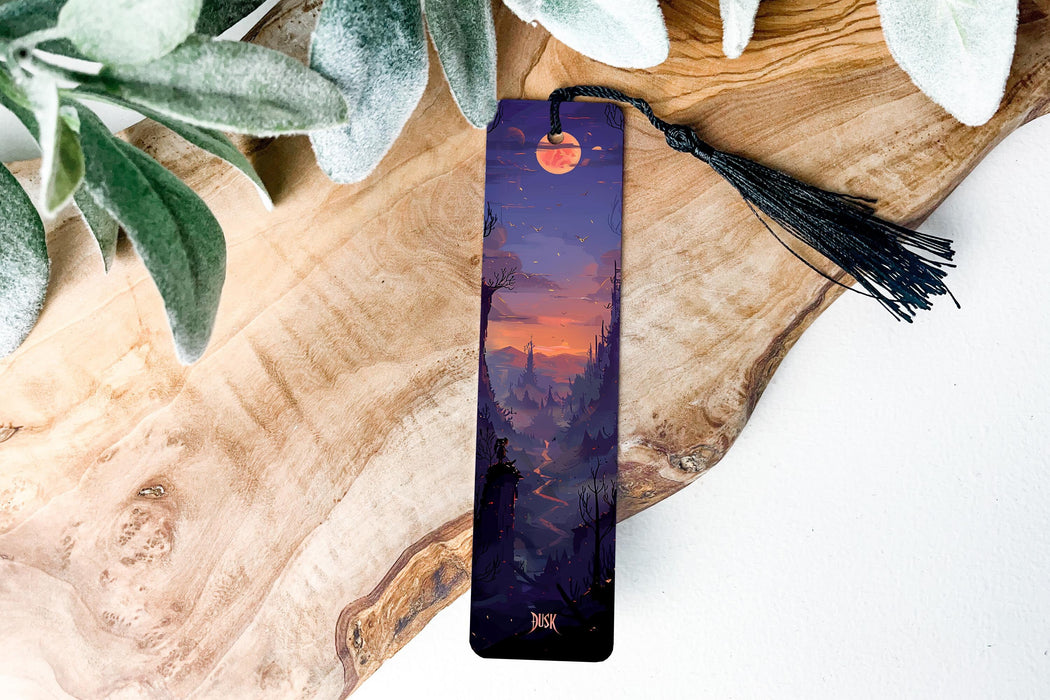 a bookmark sitting on top of a wooden table next to a plant