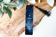 a bookmark with a name on it sitting next to a plant