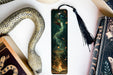 a bookmark with a snake and a book on it