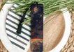 a bookmark on a plate next to a plant
