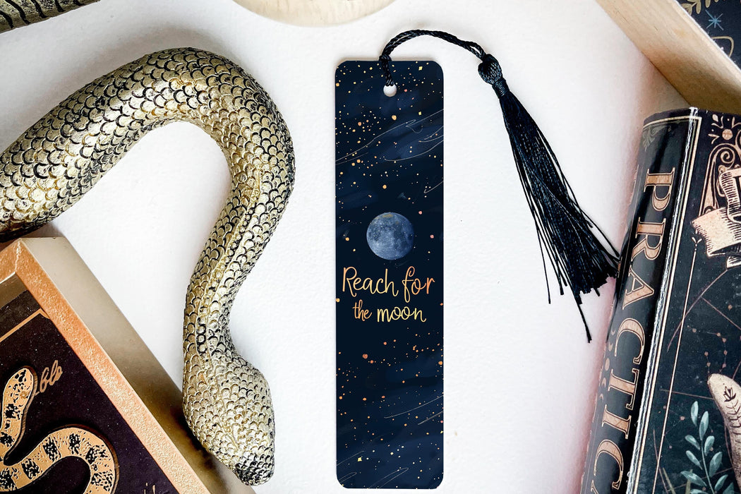 a bookmark with the words reach for the moon on it