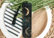 a bookmark sitting on top of a plate next to a plant