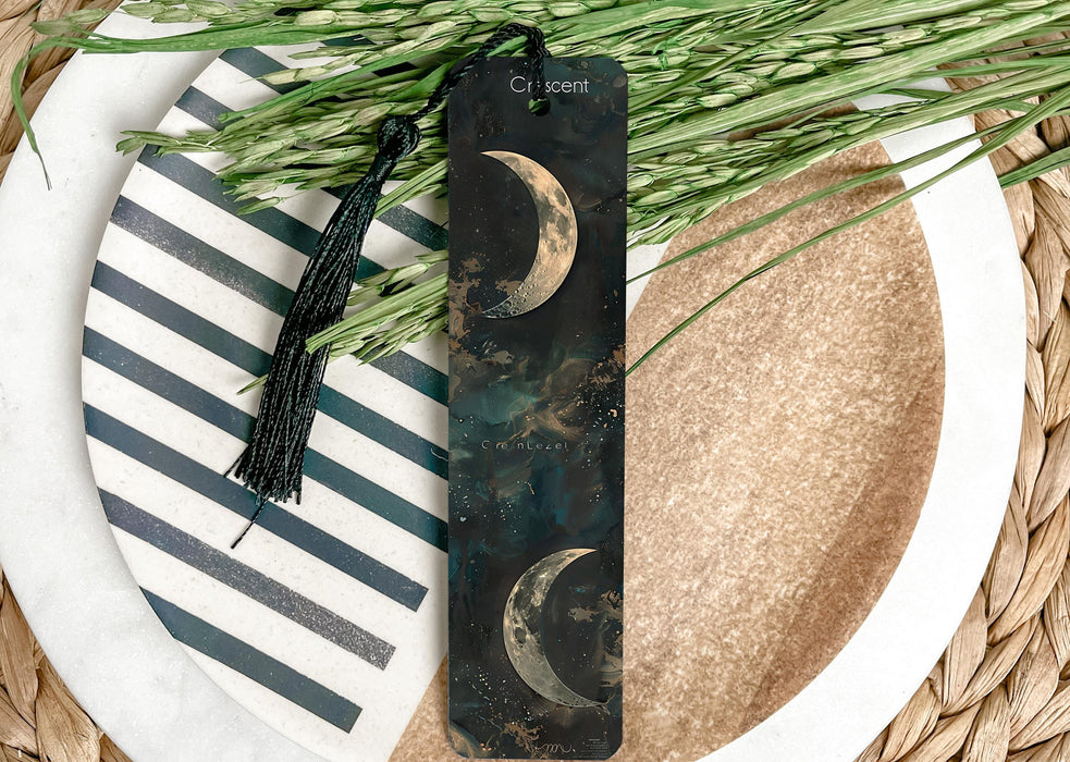a bookmark sitting on top of a plate next to a plant