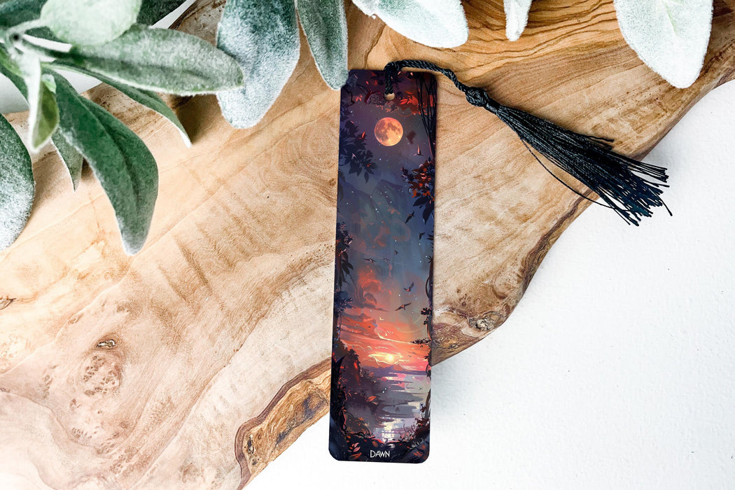a bookmark sitting on top of a wooden table next to a plant