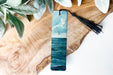 a bookmark with a painting of a boat in the ocean