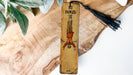 a wooden bookmark with a tassel hanging from it