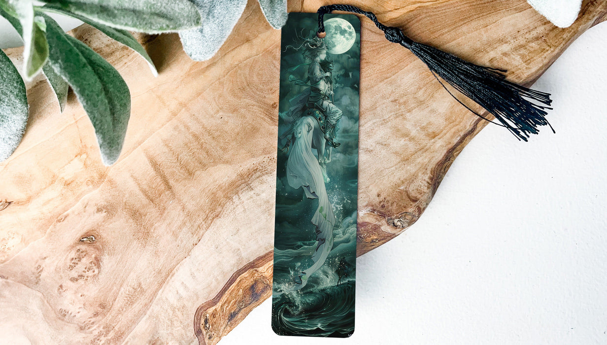 a green and black bookmark with a tassel on it