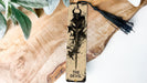 a wooden bookmark with a tassel hanging from it