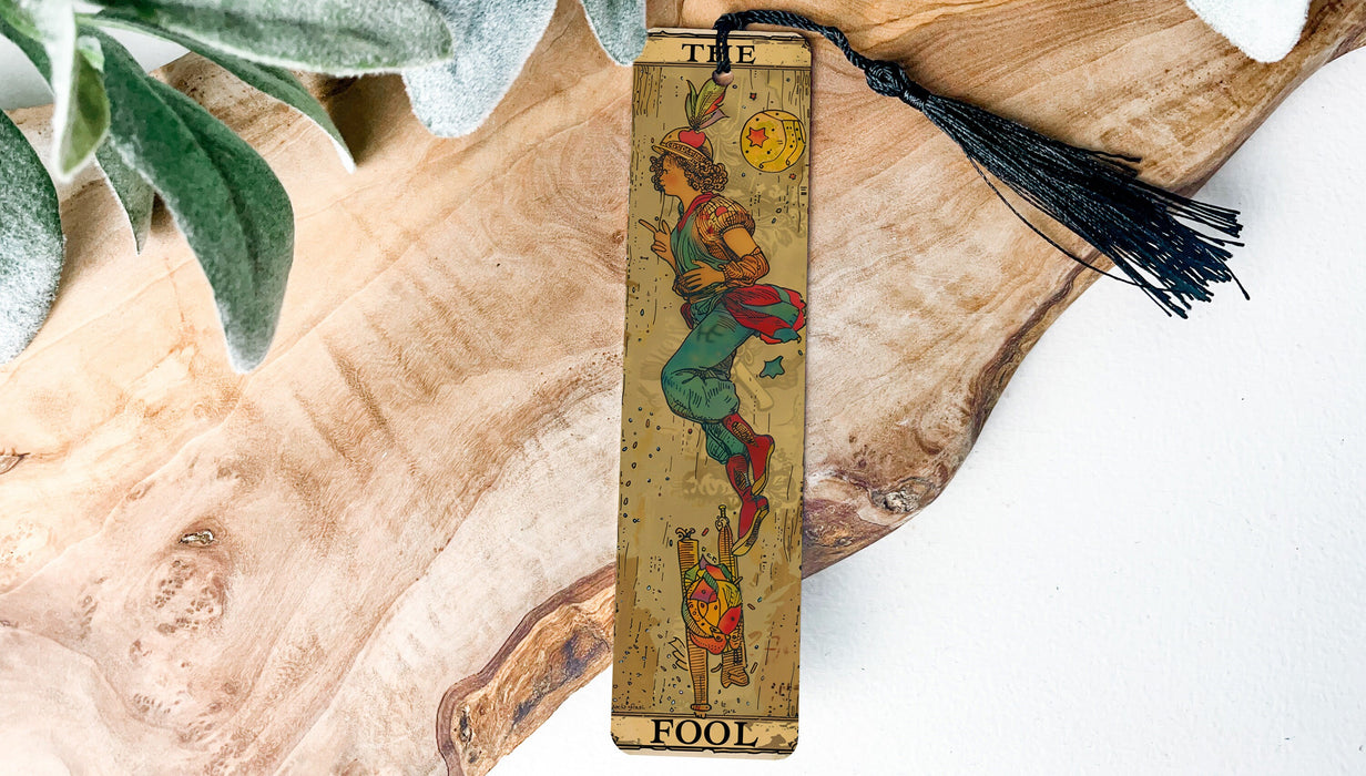 a wooden bookmark with a tassel hanging from it