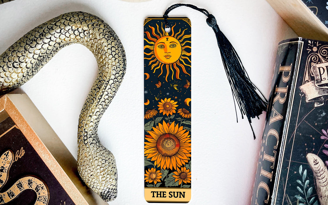 a bookmark with a sun on it next to a snake