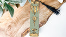 a bookmark with a tassel on top of a piece of wood