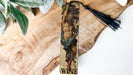 a wooden cross with a tassel hanging from it