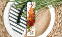 a plate with a bookmark and a plant on it