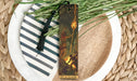 a white plate topped with a bookmark next to a plant