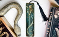 a bookmark with a snake and a book on it