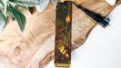 a bookmark with a painting of a man on a tree branch