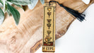 a wooden bookmark with a tassel hanging from it