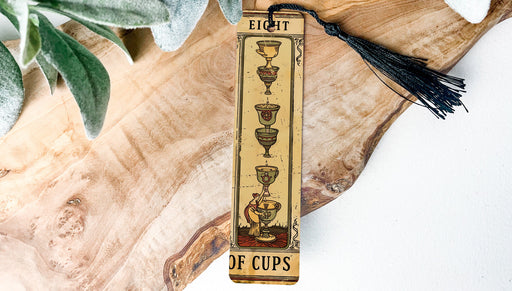 a wooden bookmark with a tassel hanging from it
