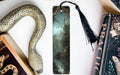 a bookmark with a snake and a book on it