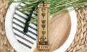a tall bookmark with a tassel on top of a plate