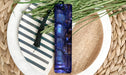 a blue glass vase sitting on top of a white plate