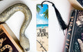 a bookmark with a picture of a beach and a snake on it