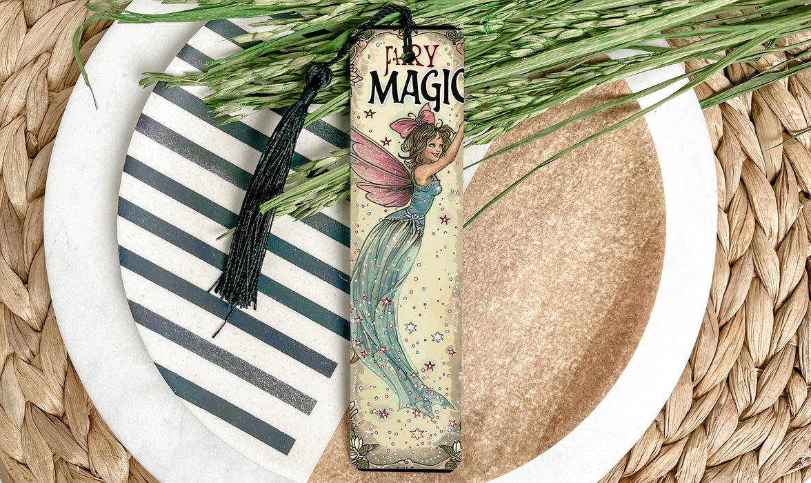 a bookmark with a fairy on it sitting on a plate
