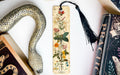 a snake, a bookmark, and two books on a table