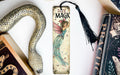 a bookmark with a fairy on it next to a snake