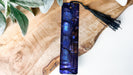 a blue glass vase sitting on top of a wooden table