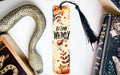 a bookmark with a snake on it next to books