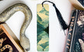 a bookmark with a snake on it next to books