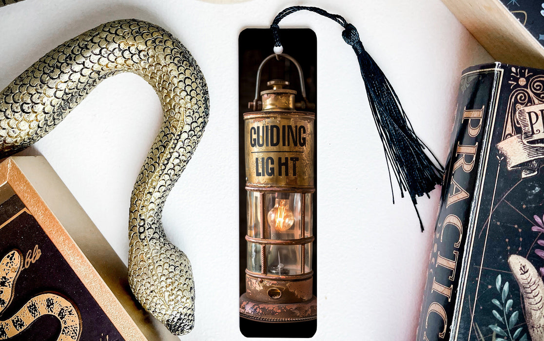 a bookmark with a snake on it next to some books