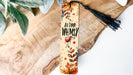 a bookmark with a tassel on top of a piece of wood