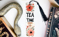 a bookmark that says tea time next to a snake