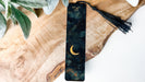 a bookmark with a crescent and a tassel hanging from it