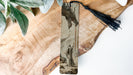 a piece of wood with a tassel hanging from it