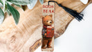 a bookmark with a picture of a bear holding a book
