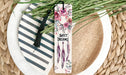 a bookmark with flowers and a tassel on a plate