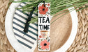a white plate topped with a cup of tea and a bookmark