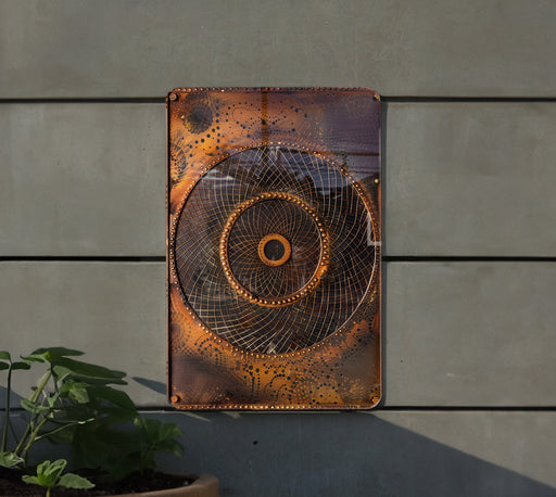 a metal art piece hanging on the side of a building