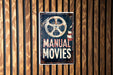 a sign on a wooden wall that says manual movies